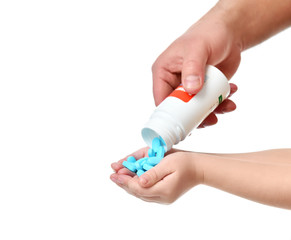 Man doctor hand pouring out prescription drugs tablet pills into a child kid hands isolated on white