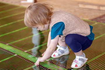 The girl helps to install a warm floor in the room.