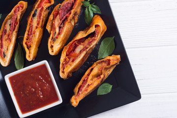 Pizza roll stromboli with cheese salami olives and tomatoes