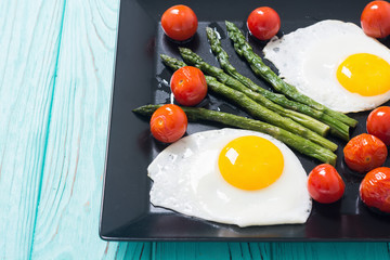 Healthy breakfast with eggs , asparagus and tomatoes