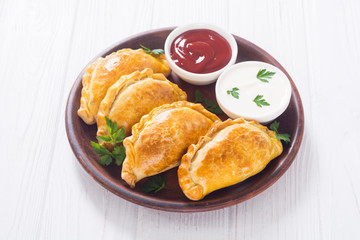 Latin American baked beef empanadas with sauce