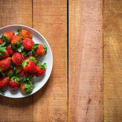 Ripe red strawberries on wooden table with copy space for text. Simple healthy food concept.