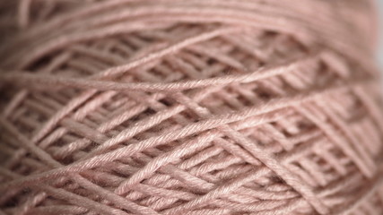Closeup light pink colored yarn ball.