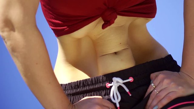Close-up shot of a woman doing belly dancing outside.