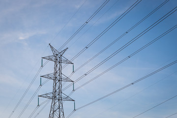 High voltage post tower with blue sky before sunset