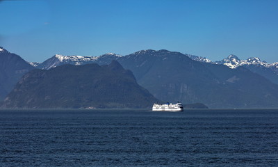 The ferry makes a regular flight from Vancouver to Nanaimo, sunny day, blue sky, blue water at the background of snow covered mountain range