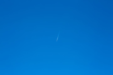 blue sky with a plane flying high
