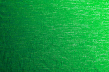 A uniformly lit green fabric texture with soft shadows.