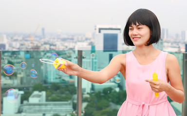 Young asian woman playing bubble outdoor.