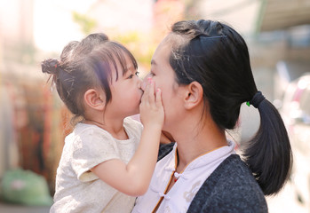 Naklejka premium Happy loving family, mother and child girl kissing.
