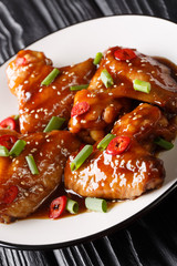 Asian chicken wings in teriyaki sauce close-up on a plate. vertical