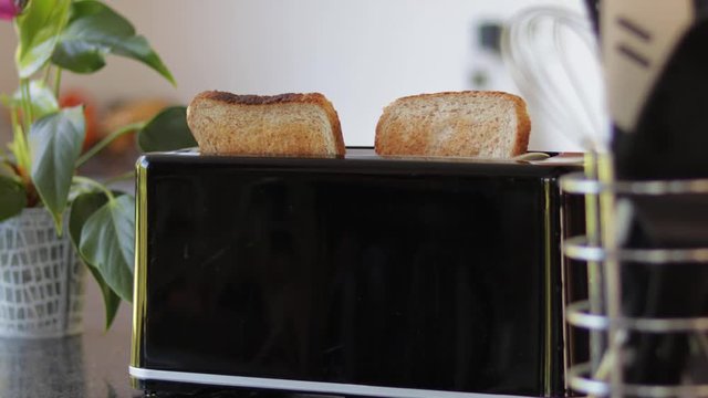 toast jumping out of black modern toaster in fancy kitchen with props and depth of field, still shot