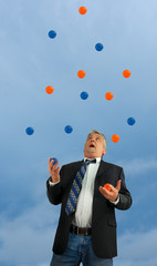 Disheveled out of control man juggling a lot of several balls in the air representing extremely...