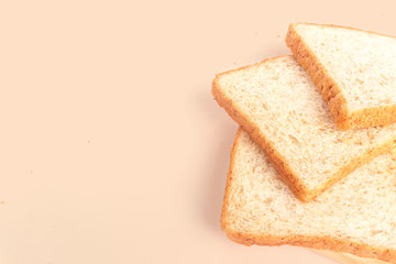 Close up brown sliced whole wheat bread isolated on pastel background.Healthy homemade sandwich breakfast preparing.Cooking bio ingredients.Food background concept with copy space.Top view.