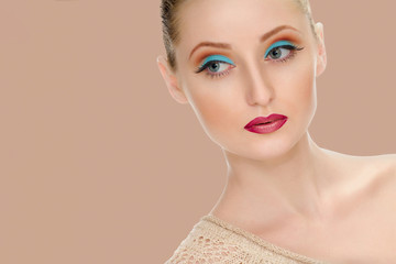 Woman with Beautiful face and fashion style blue make-up - on background peach shade yellow