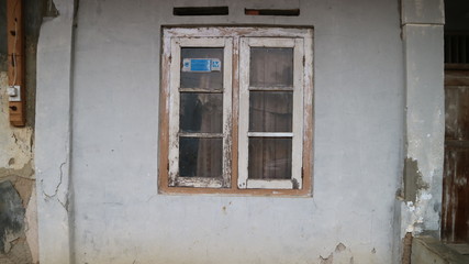 Fototapeta na wymiar Old Window Frame on the crack grey wall