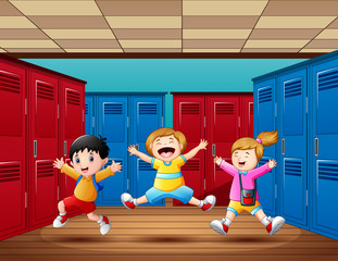 Three kids jumping and laughing in locker room