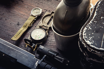 Military tactical equipment for the departure. Assortment of survival hiking gear on wooden...