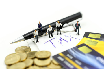 Miniature people : businessman with credit card and stack coins of tax commitment, agreement,...