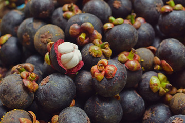 Heap of mangosteen fruits in market.