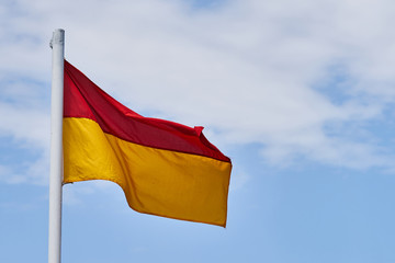 Lifeguard flag and blue sky background