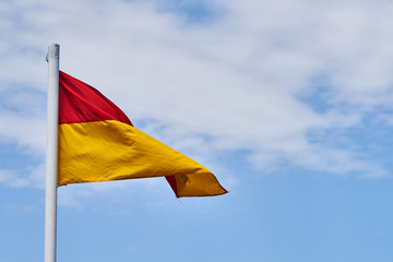 Lifeguard flag and blue sky background