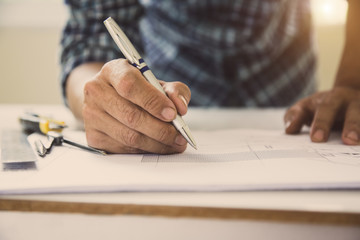 architect man handwriting with blueprint to build houses. After agreeing the employment price the...