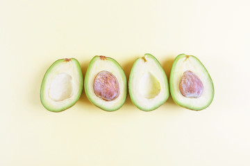 Cut avocado on a light background. The concept of vegetarianism, healthy eating, organic food rich in vitamins. Minimalism, top view, flat lay. Copy space. Design, summer concept.