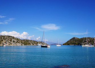Blue lagoon with yachts. Ships stand near the shore against the backdrop of a beautiful landscape.