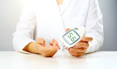Photo of doctor's hand with glucometer with inscription five in studio