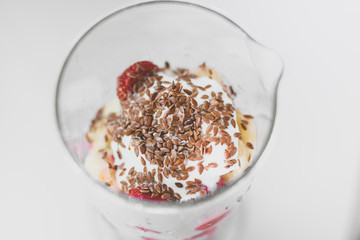 Strawberries smoothie with linseeds and bananas, healthy and useful drink, gray background.