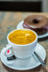 Coffee with milk and chocolate donut. (closeup)