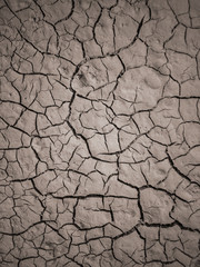 Texture of dry cracked earth. The desert background. The global shortage of water. Deep cracks in brown land as symbol of hot climate and drought.
