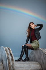 Young girl sitting on the wooden cable coil