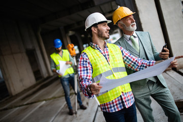 Construction engineers discussion with architects at construction or building site