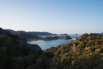 Beautiful summer seascape. Mountain coast of the blue sea. Rocks and forest near the ocean coast.