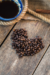 Heart symbol, roasted coffee beans in rustic wooden background