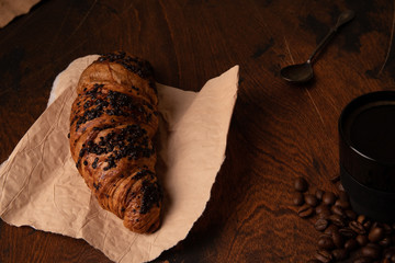 a shot of espresso and a croissant on wooden background