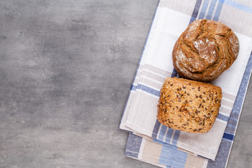 Gold rustic crusty loaves of bread and buns on wooden background. Still life captured from above top view, flat lay.