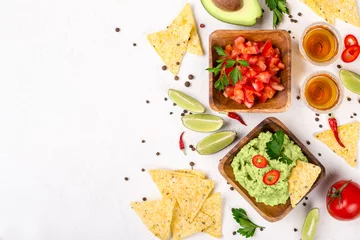 Photo sur Plexiglas Manger Sélection de plats mexicains : sauce guacamole, salsa, chips et coups de tequila au citron vert sur fond blanc