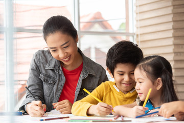 Asian Teacher teaching Art and coloring with little kids.