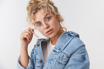 Smart creative attractive fashionable female magazine editor touch rim glasses tilting head...