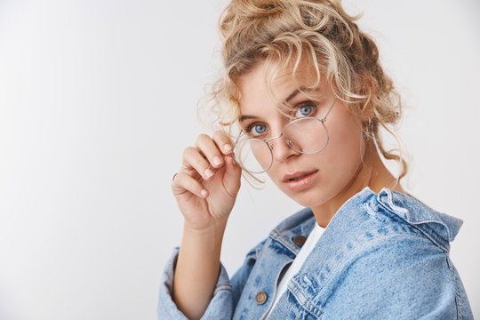 Close-up curious questioned attractive smart fashionable blue-eyed curly-haired blond female student study charts working look interested touch glasses, standing intrigued white background