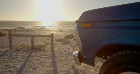 Blue pickup truck parked on the beach