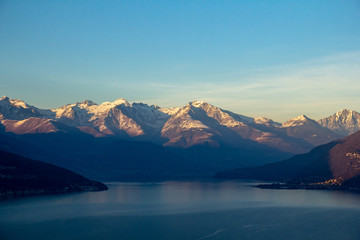 Fototapeta na wymiar Flight over Lake Como at sunset. View of the mountains (Alps) in the light of the setting sun. Italy