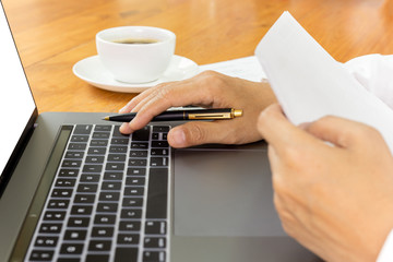 Fototapeta na wymiar Businessman working on laptop with paperwork on table.