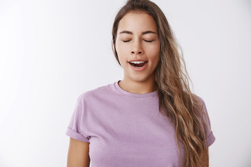 Attractive cute silly young female wake up early making coffee yawning morning close eyes open...