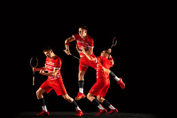 Young man playing badminton isolated on black background in mixed light. Male model in sportwear and sneakers with the racket in action, motion in game. Concept of sport, movement, healthy lifestyle.