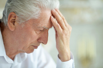 Fototapeta premium Beautiful sad thinking senior man posing at home