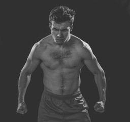 Fototapeta na wymiar Portrait of strong angry fitness man on dark background